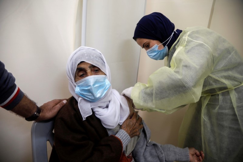 &copy; Reuters. FOTO DE ARCHIVO. Una sanitaria palestino administra a una mujer una dosis de la vacuna de AstraZeneca contra la enfermedad del coronavirus (COVID-19) durante una campaña de vacunación en Tubas, en la Cisjordania ocupada por Israel. 25 de marzo de 2021. 