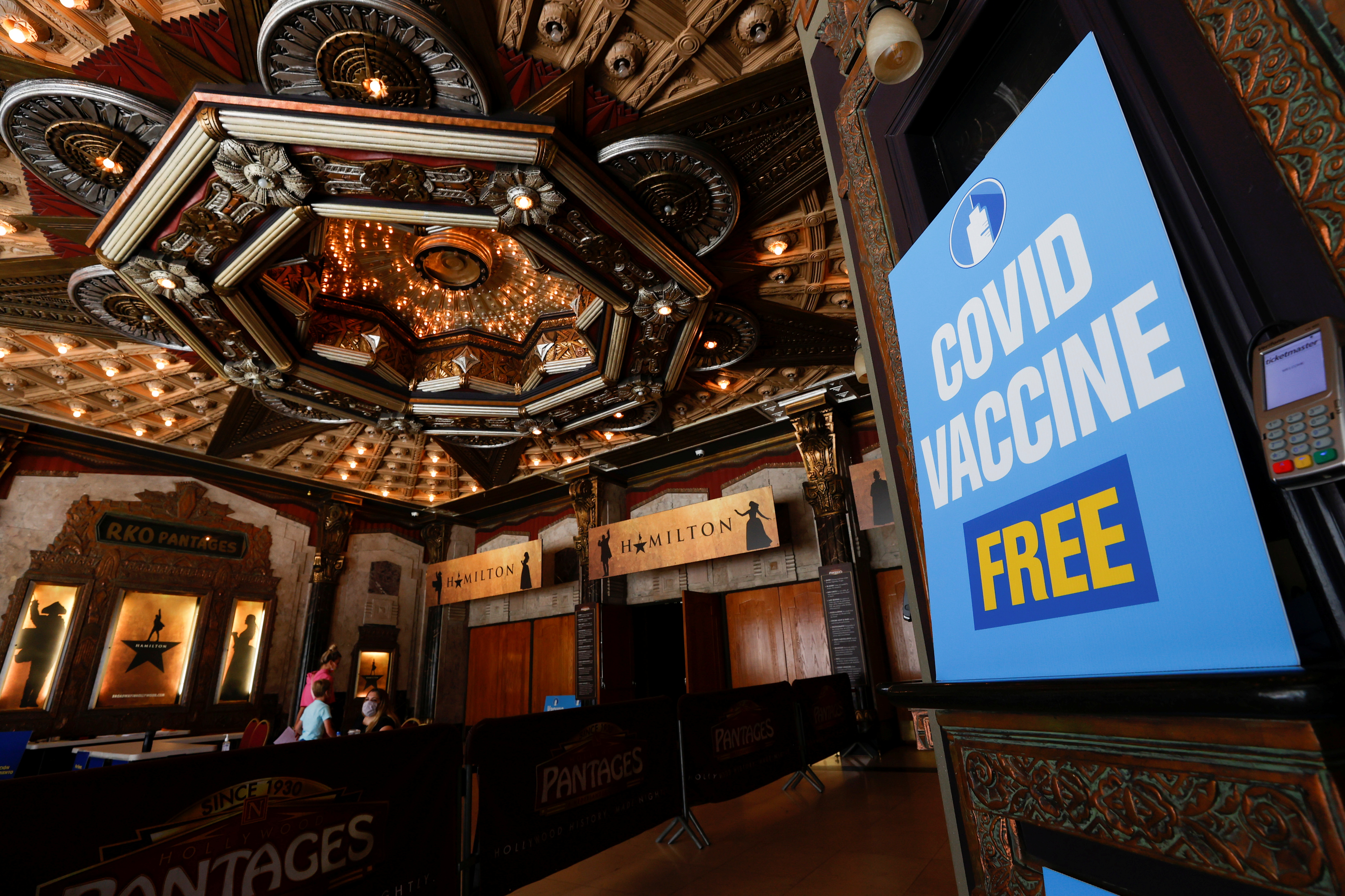&copy; Reuters. FILE PHOTO: People walk in to receive a coronavirus disease (COVID-19) vaccine with a chance to win a pair of tickets to see "Hamilton" at a pop-up vaccination clinic at Pantages theatre in Los Angeles, California, U.S., June 12, 2021.  REUTERS/Mario Anzu
