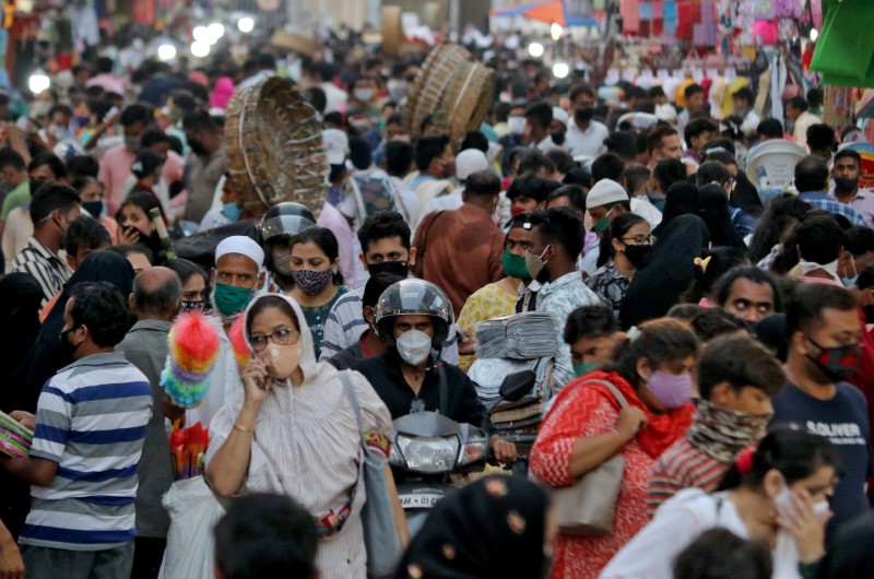 &copy; Reuters. أشخاص يضعون كمامات للوقاية من فيروس كورونا بسوق في مدينة مومباي الهندية يوم 22 مارس آذار 2021. تصوير: نيهاريكا كولكارني - رويترز.