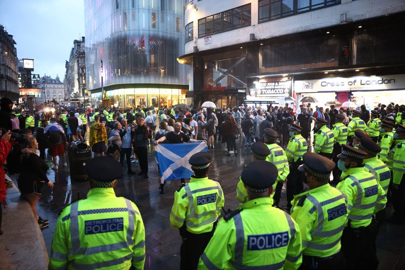 &copy; Reuters. ضباط شرطة يحيطون بمشجعين من اسكتلندا في العاصمة البريطانية لندن بوم الجمعة. تصوير: هنري نيكولز - رويترز.