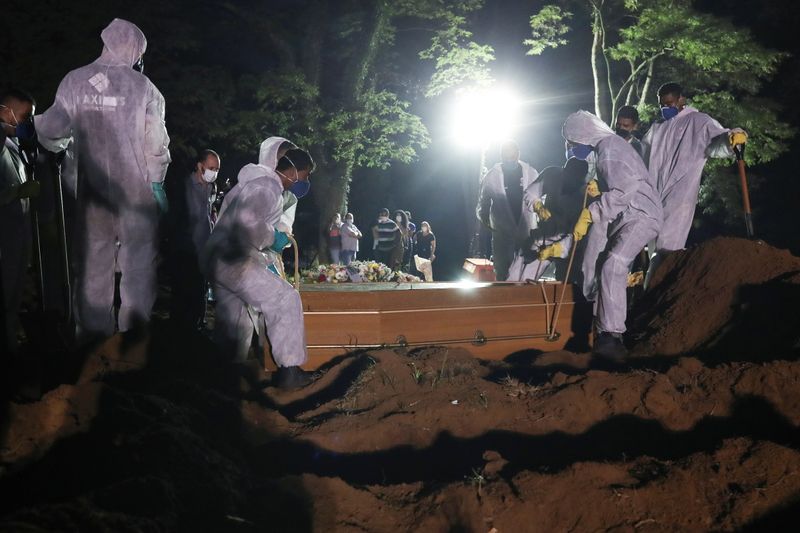 &copy; Reuters. Coveiros com trajes de proteção fazem o sepultamento noturno no cemitério de Vila Formosa, em São Paulo
25/03/2021
REUTERS/Amanda Perobelli