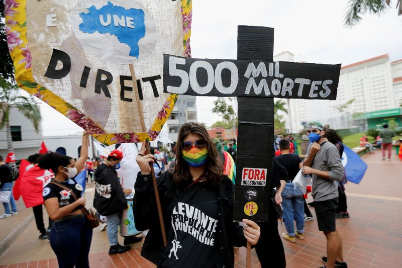 &copy; Reuters. Una persona sostiene una cruz que dice "500 mil muertes" en medio de una protesta contra el presidente de Brasil, Jair Bolsonaro, y su gestión de la pandemia de COVID-19, en Cuiabá, Brasil. 19 de junio, 2021. REUTERS/Mariana Greif
