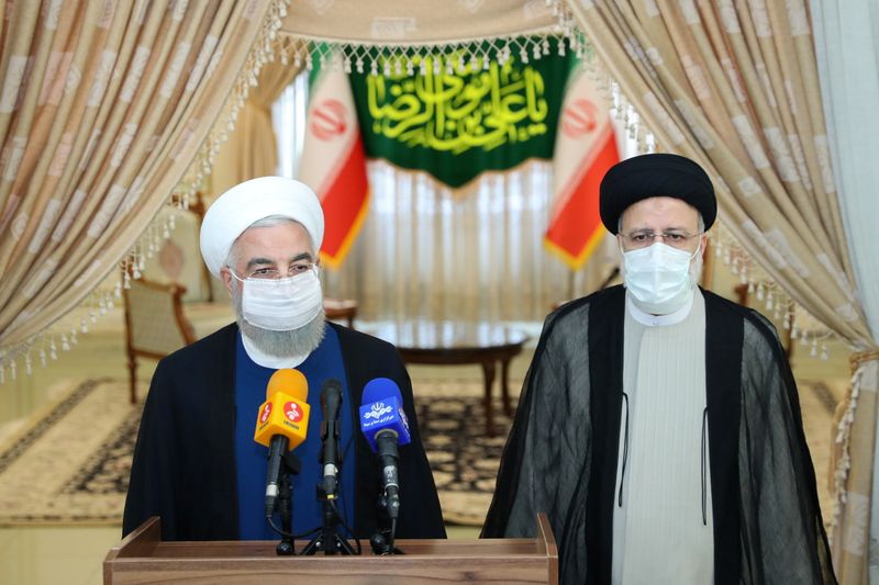 &copy; Reuters. 　６月１９日　イラン大統領選挙で反米・保守強硬派のライシ司法府代表が当選した。写真は会談後に会見するライシ師（右）とロウハニ現大統領。６月１９日、テヘランで撮影（２０２１