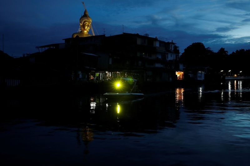 &copy; Reuters. FILE PHOTO: The giant Buddha statue of Wat Paknam Phasi Charoen temple is seen behind a community nearby a canal in Bangkok, Thailand, June 16, 2021. REUTERS/Jorge Silva