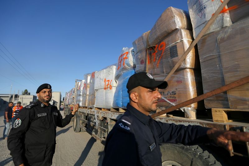 &copy; Reuters. Palestinian police officers stand next to a truck carrying clothes for export at Kerem Shalom crossing in Rafah in the southern Gaza Strip, June 21, 2021. REUTERS/Ibraheem Abu Mustafa