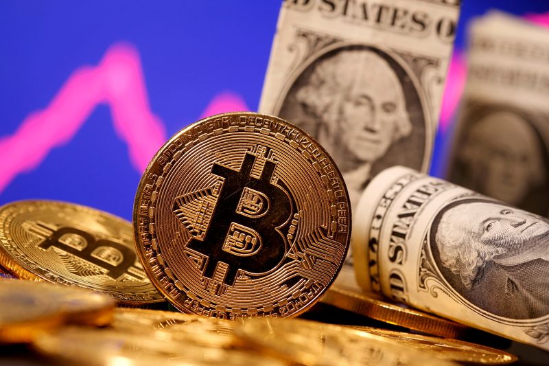 &copy; Reuters. Monete bitcoine banconote da un dollaro statunitense. REUTERS/Dado Ruvic