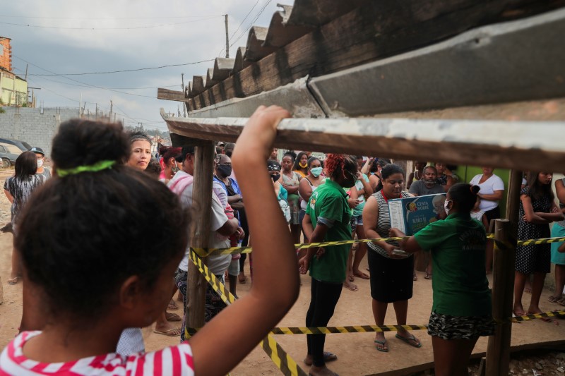 &copy; Reuters. FILE PHOTO: A woman receives a box with food donations organized by NGO Kapadocia Institute for poor families from Capadocia Slum at Brasilandia district amid the coronavirus disease (COVID-19) outbreak, in Sao Paulo, Brazil, May 1, 2020.REUTERS/Amanda Pe