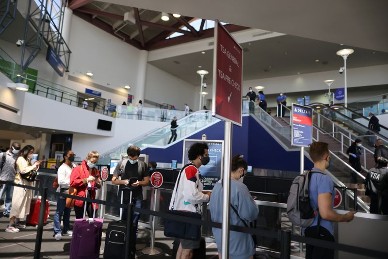 &copy; Reuters. FILE PHOTO: Passengers queue at LAX airport before Memorial Day weekend, as the coronavirus (COVID-19) disease continues, in Los Angeles, California, U.S., May 27, 2021. REUTERS/Lucy Nicholson