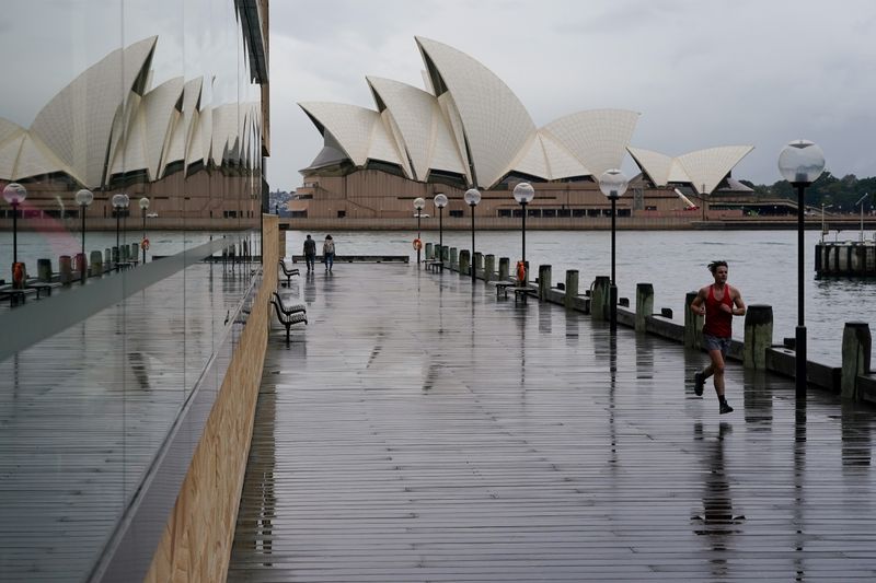 © Reuters. FILE PHOTO: A runner exercises along the waterfront near the Sydney Opera House in Sydney, Australia, June 10, 2021.  REUTERS/Loren Elliott