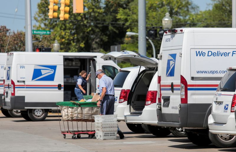 &copy; Reuters. FILE PHOTO: United States Postal Service (USPS) workers load mail into delivery trucks outside a post office in Royal Oak, Michigan, U.S. August 22, 2020. REUTERS/Rebecca Cook
