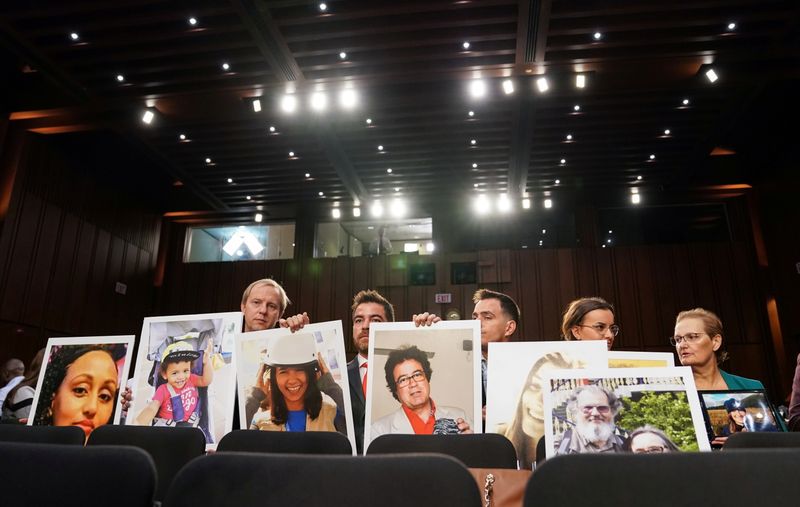 &copy; Reuters. FILE PHOTO: Family members hold photographs of Boeing 737 MAX crash victims lost in two deadly 737 MAX crashes that killed 346 people as Boeing CEO Dennis Muilenburg testifies before a Senate Commerce, Science and Transportation Committee hearing on “av