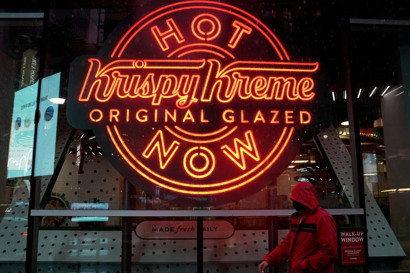 &copy; Reuters. FILE PHOTO: A man walks past a Krispy Kreme "Hot Now" neon sign in Times Square in the Manhattan borough of New York City, New York, U.S., October 16, 2020. REUTERS/Carlo Allegri