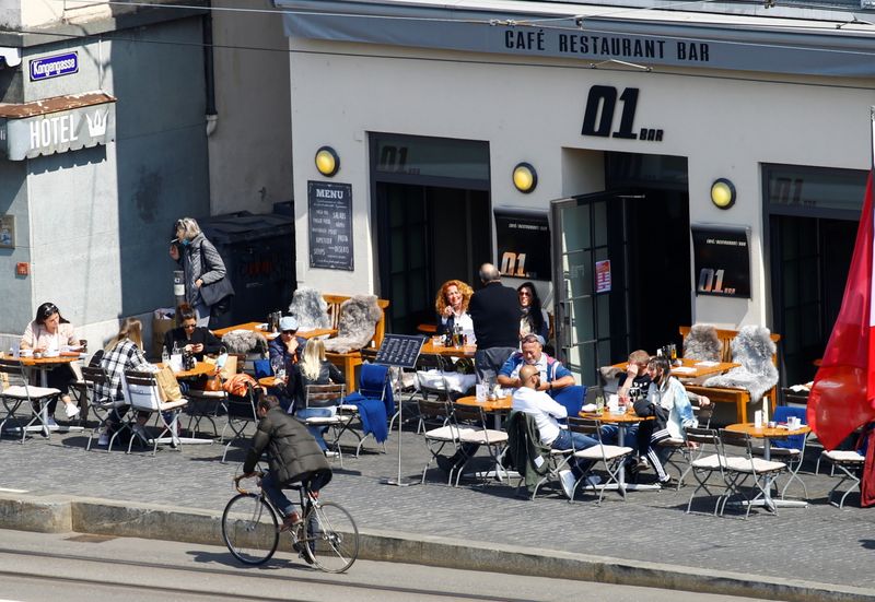 &copy; Reuters. Guests enjoy the sunny weather as they sit in front of a restaurant after Swiss government allowed to reopen outdoor terraces, as the spread of the coronavirus disease (COVID-19) continues, on Muensterhof square in Zurich, Switzerland April 20, 2021. REUT