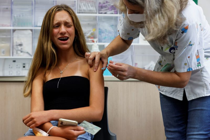 &copy; Reuters. فتاة تتلقى جرعة من اللقاح المضاد لكوفيد-19 في تل أبيب يوم 21 يونيو حزيران 2021. تصوير: أمير كوهين - رويترز.