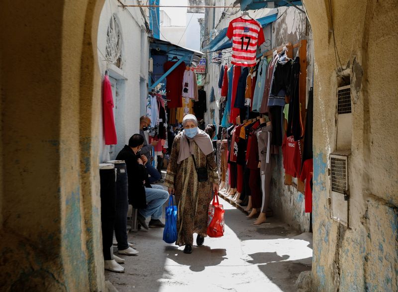 &copy; Reuters. امرأة تضع كمامة على وجهها لدى سيرها في مدينة تونس القديمة بالعاصمة يوم 29 أبريل نيسان 2021. تصوير: زبير السوسي - رويترز  