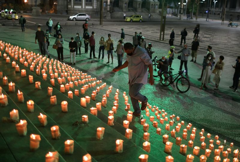 &copy; Reuters. رجل يشارك في مراسم إشعال 500 ألف شمعة أقيمت في ريو دي جانيرو تكريما لمن لاقوا حتفهم في البرازيل يوم 21 يونيو حزيران 2021. تصوير: بيلار أوليفاريس - 