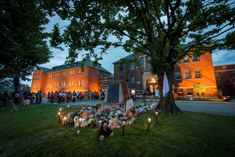&copy; Reuters. FILE PHOTO: Kamloops residents and First Nations people gather to listen to drummers and singers at a memorial in front of the former Kamloops Indian Residential School after the remains of 215 children, some as young as three years old, were found at the