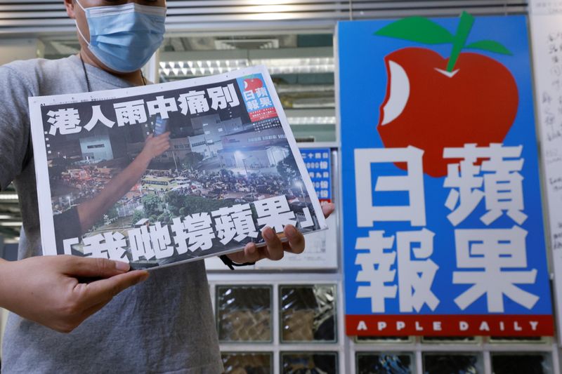&copy; Reuters. A staff member of Apple Daily poses with his final edition of Apple Daily at its headquarters in Hong Kong, China June 24, 2021. REUTERS/Tyrone Siu