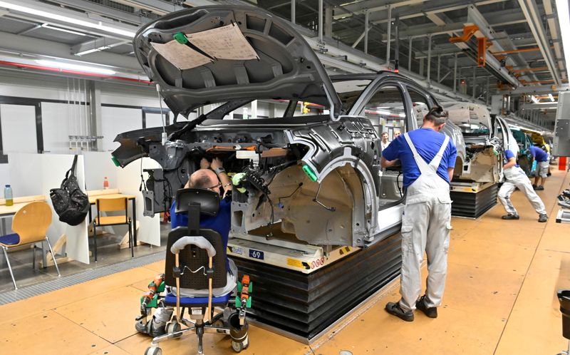 © Reuters. FILE PHOTO: Technicians work at the assembly line of Volkswagen's electric ID.3 car in Zwickau, Germany, June 23, 2021. REUTERS/Matthias Rietschel/File Photo