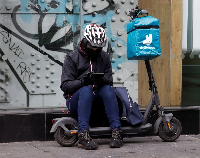 &copy; Reuters. FILE PHOTO: A Deliveroo rider sits outside a fast food restaurant in Liverpool, Britain, April 7, 2021. REUTERS/Phil Noble
