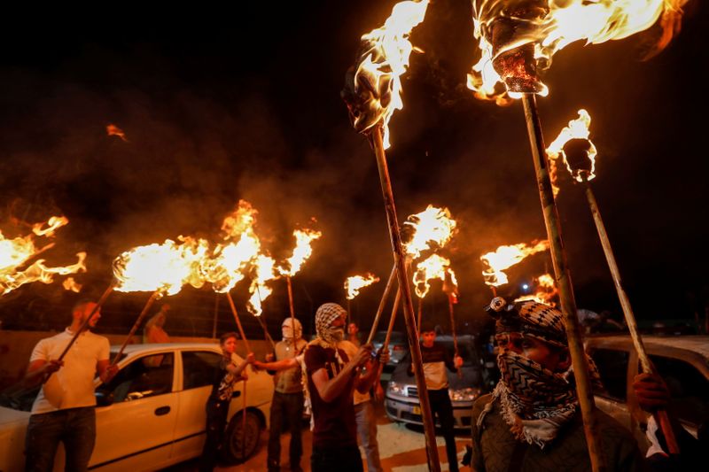 &copy; Reuters. Palestinian demonstrators hold torches during a night protest against Israeli settlements in Beita in the Israeli-occupied West Bank, June 22, 2021. REUTERS/Mohamad Torokman