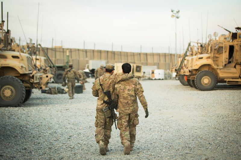 &copy; Reuters. FILE PHOTO: A U.S. soldier from the 3rd Cavalry Regiment walks with the unit's Afghan interpreter before a mission near forward operating base Gamberi in the Laghman province of Afghanistan December 11, 2014. REUTERS/Lucas Jackson/File Photo