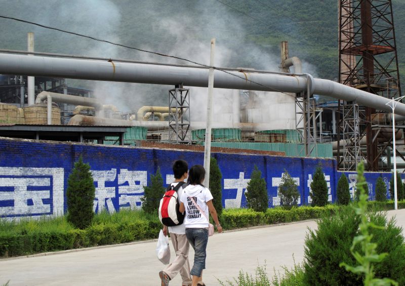 &copy; Reuters. Residents walk past a zinc smelter belonging to the Dongling Group, in Fengxian county, Shaanxi province, August 22, 2009.   REUTERS/Lucy Hornby/File Photo