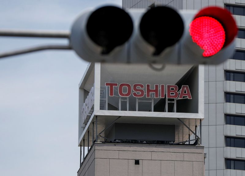 © Reuters. FILE PHOTO: The logo of Toshiba Corp. is seen next to a traffic signal atop of a building in Tokyo, Japan June 11, 2021.  REUTERS/Issei Kato/File Photo