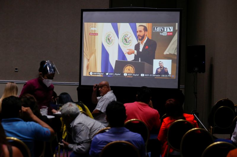 © Reuters. People watch El Salvador President Nayib Bukele on an online transmission during a Bitcoin investment event, in San Salvador, El Salvador June 24, 2021. REUTERS/Jose Cabezas