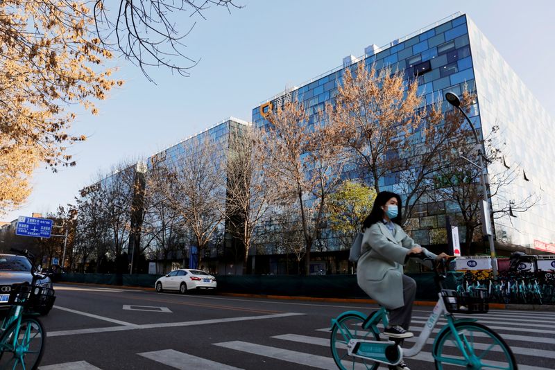 &copy; Reuters. A woman rides a Didi shared bicycle past the headquarters of Didi Chuxing in Beijing, China November 20, 2020. REUTERS/Florence Lo/File Photo