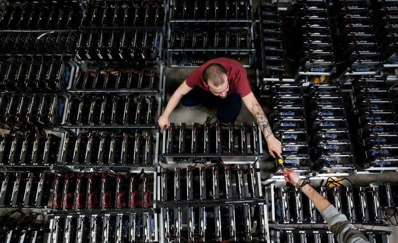 &copy; Reuters. Employees work on bitcoin mining computers at Bitminer Factory in Florence, Italy, April 6, 2018. Picture taken April 6, 2018. REUTERS/Alessandro Bianchi/File Photo