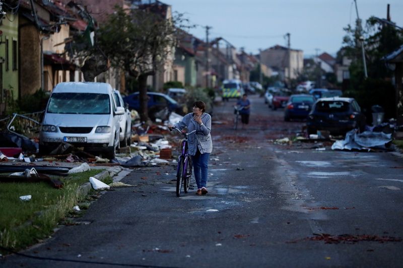 &copy; Reuters. Varias personas caminan por una calle llena de escombros tras el paso de un infrecuente tornado en el pueblo de Moravská Nová Ves, República Checa, el 25 de junio de 2021. REUTERS/David W Cerny