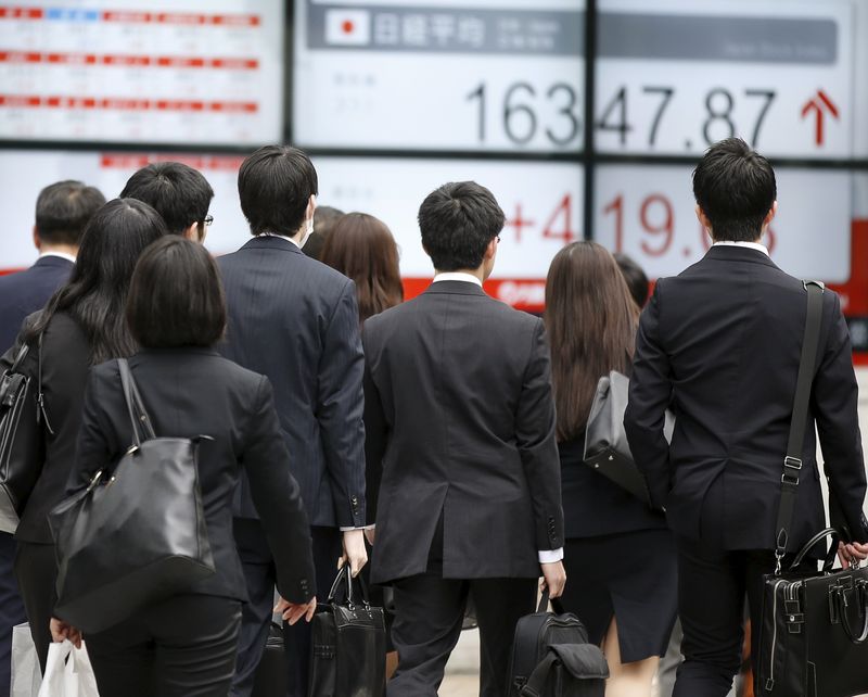 &copy; Reuters. FILE PHOTO: People walk in front of an electronic board showing Japan's Nikkei average outside a brokerage in Tokyo, Japan, April 13, 2016.   REUTERS/Toru Hanai