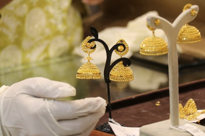&copy; Reuters. Customer looks at gold earrings at a jewellery showroom during Dhanteras, a Hindu festival associated with Lakshmi, the goddess of wealth, amidst the spread of COVID-19 in Mumbai, November 13, 2020. REUTERS/Niharika Kulkarni/Files