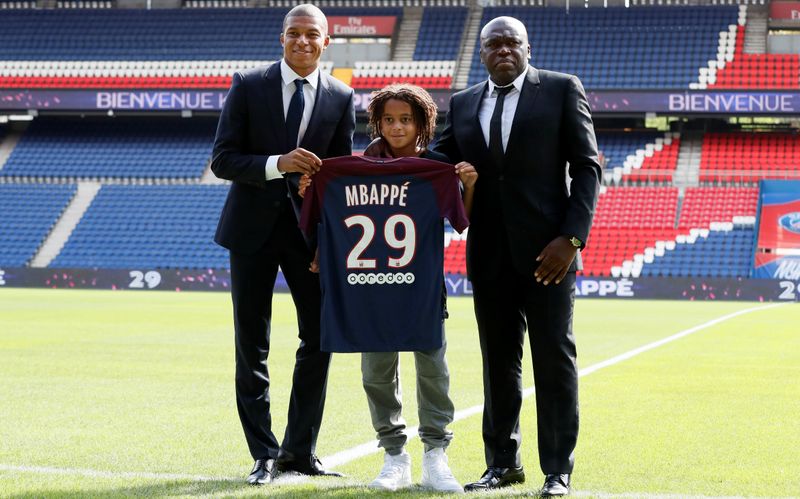 &copy; Reuters. サッカーのフランス１部ＰＳＧは、同クラブに所属するフランス代表ＦＷキリアン・エムバペ（左）の弟イーサン（中央）と３年のユース契約を結んだと発表した。写真はパリで２０１７年