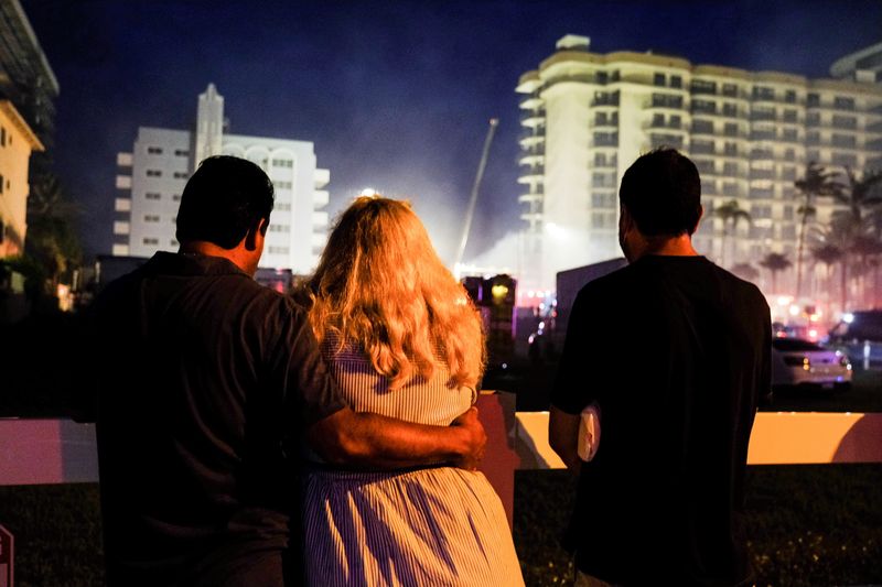 &copy; Reuters. FILE PHOTO: People stand near the partially collapsed residential building in Surfside, as the emergency crews continue search and rescue operations for survivors, near Miami Beach, Florida, U.S. June 25, 2021.  REUTERS/Maria Alejandra Cardona/