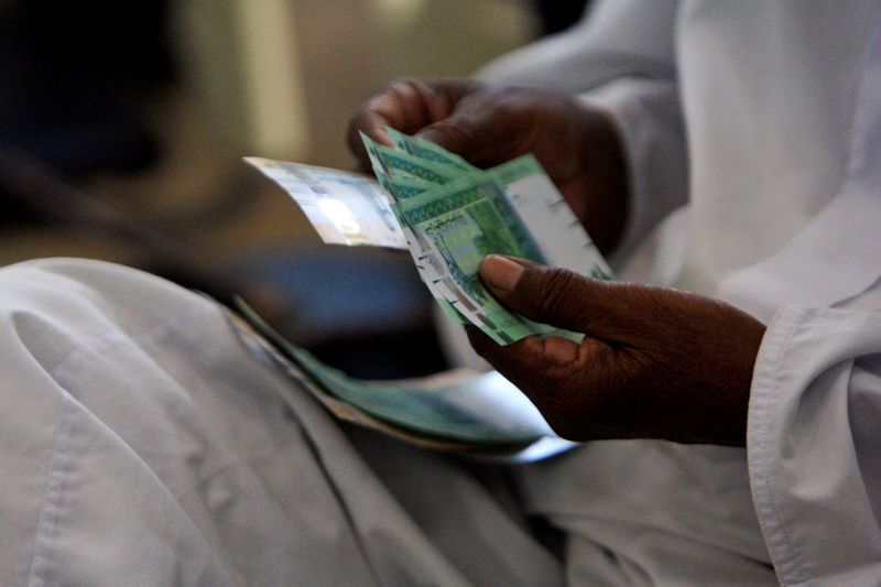 &copy; Reuters. FILE PHOTO: A man counts notes after receiving the new Sudanese currency at a central bank branch in Khartoum July 24, 2011. REUTERS/ Mohamed Nureldin Abdallah//File Photo