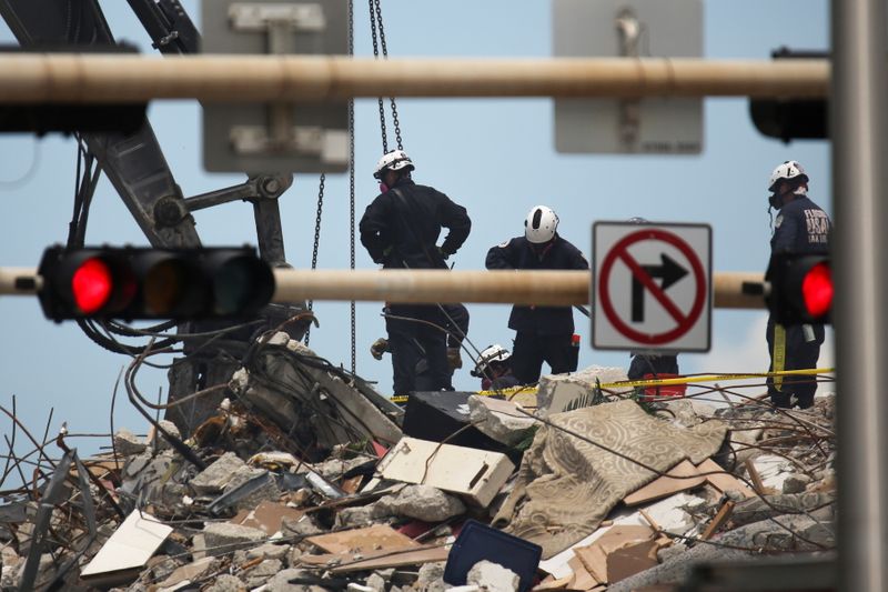 © Reuters. عمال انقاذ يواصلون البحث عن ناجين بين حطام مبنى انهار في سيرفسايد بولاية فلوريدا الأمريكية يوم السبت. تصوير: ماركو بيلو-رويترز.