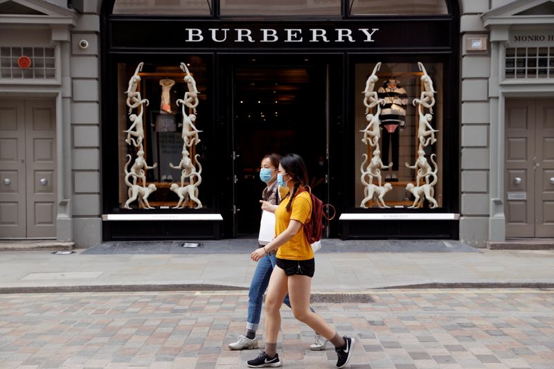 &copy; Reuters. FILE PHOTO: People wearing protective masks walk past a Burberry store at Covent Garden, in London, Britain June 15, 2020. REUTERS/John Sibley/File Photo