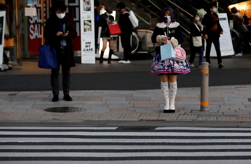&copy; Reuters. FILE PHOTO: Pedestrians wearing protective masks amid the coronavirus disease (COVID-19) outbreak stand in front of a cross walk at a shopping district in Tokyo, Japan, December 17, 2020. REUTERS/Kim Kyung-Hoon/File Photo  