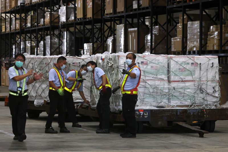 &copy; Reuters. FILE PHOTO: Workers transport Moderna vaccines against the coronavirus disease (COVID-19) shipped from the United States, to Taiwan Air Cargo Terminal at the Taoyuan International Airport in Taoyuan, Taiwan, June 20, 2021. REUTERS/Ann Wang
