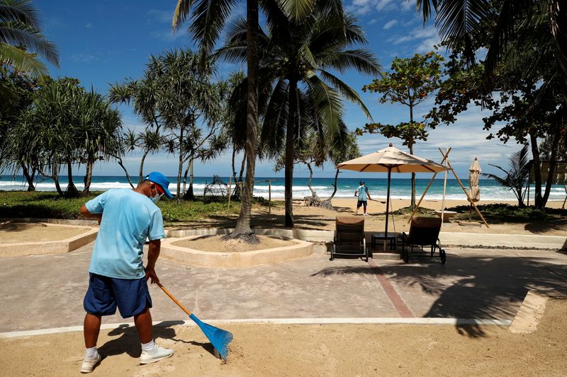 © Reuters. A man rakes the sand on a beach as Phuket gets ready to open to overseas tourists from July 1 allowing fully vaccinated foreigns to visit the resort island without quarantine, Phuket, Thailand June 29, 2021. REUTERS/Jorge Silva