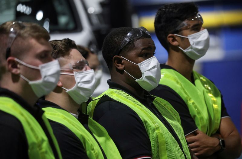 &copy; Reuters. FILE PHOTO: Workers in protective face masks listen as U.S. President Donald Trump delivered a speech during his visit to the Ford Rawsonville Components Plant, which is making ventilators and medical supplies, during the coronavirus disease (COVID-19) pa