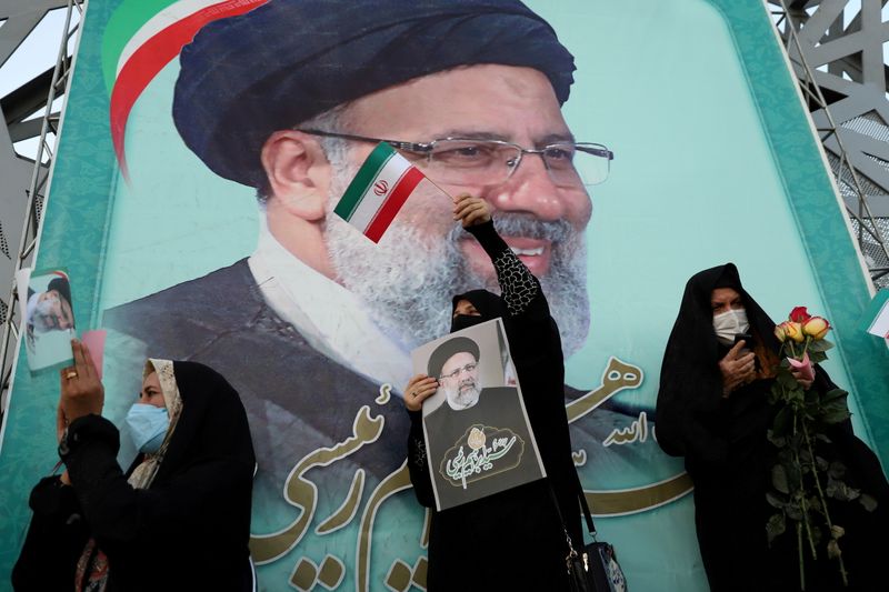 © Reuters. FILE PHOTO: A supporter of Ebrahim Raisi displays his portrait during a celebratory rally for his presidential election victory in Tehran, Iran June 19, 2021. Majid Asgaripour/WANA (West Asia News Agency) via REUTERS  