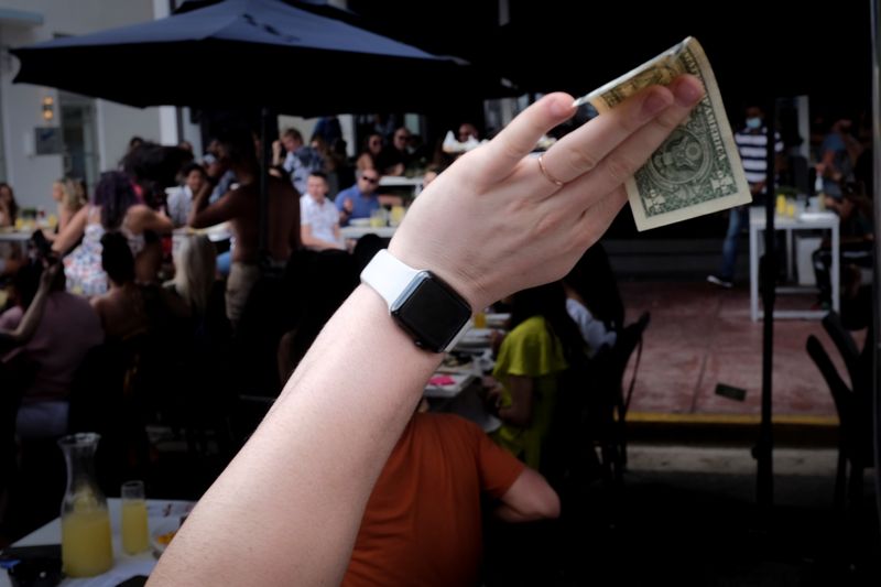 &copy; Reuters. Homem segura uma nota de dólar em um bar em Miami Beach, Flórida, EUA
06/03/2021
REUTERS/Marco Bello