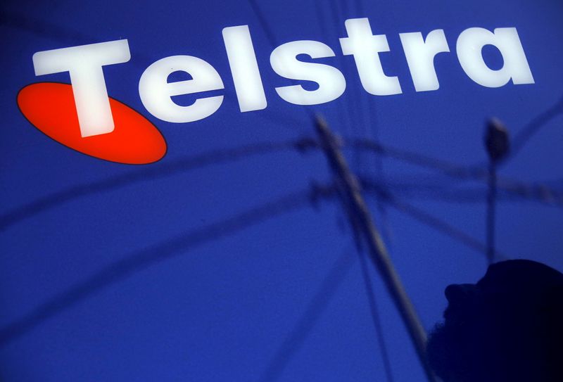 &copy; Reuters. FILE PHOTO: A man and power lines are reflected in a Telstra poster adorning a public telephone in Sydney, Australia, August 13, 2015. REUTERS/David Gray/File Photo