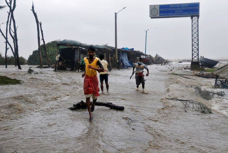 &copy; Reuters. IMAGEN DE ARCHIVO. Personas corren por un camino inundado debido al aumento del nivel del mar antes del paso del ciclón Yaas, en Digha, India, Mayo 26, 2021. REUTERS/Rupak De Chowdhuri
