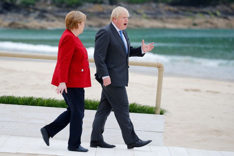 &copy; Reuters. FILE PHOTO: Britain's Prime Minister Boris Johnson walks next to German Chancellor Angela Merkel, during the G7 summit in Carbis Bay, Cornwall, Britain, June 11, 2021. REUTERS/Phil Noble/Pool/File Photo
