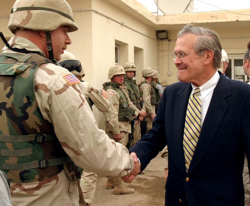 &copy; Reuters. Foto de archivo. El secretario de Defensa de Estados Unidos Donald Rumsfeld saludando a un soldado en la prisión de Abu Ghraib en las afueras de Bagdad. Mayo 13, 2004. REUTERS/Jim MacMillan