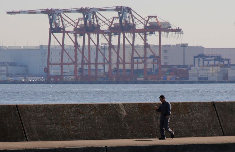 &copy; Reuters. FILE PHOTO: A man walks in front of containers and cranes at an industrial port in Tokyo, Japan September 29, 2017. REUTERS/Toru Hanai